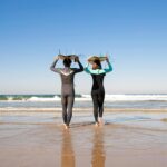 Two surfers walking into the ocean for a surf lesson in Santa Monica California