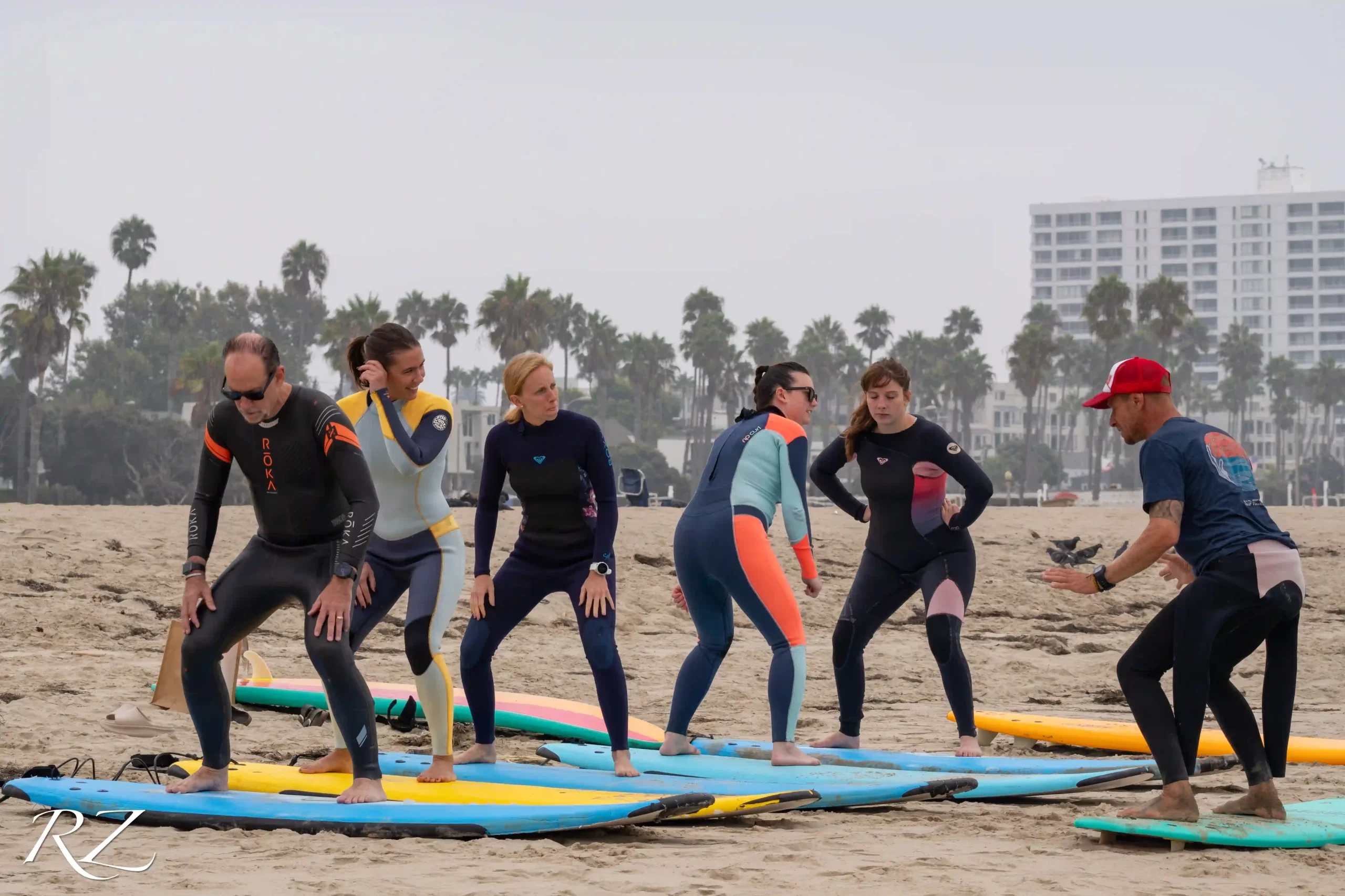 Happy students learning to surf at Offshore Vibes Surf School in Santa Monica.